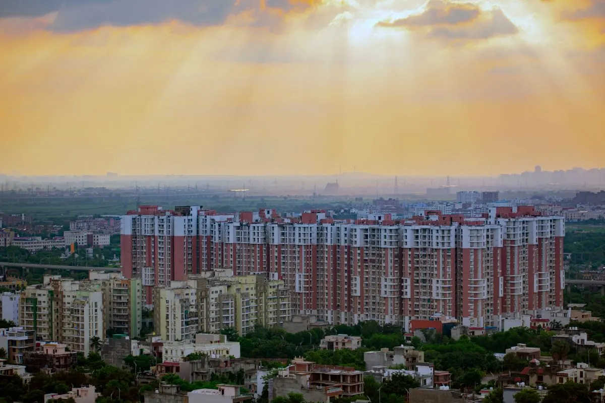 High-rise apartment blocks across the Delhi NCR skyline at golden hour